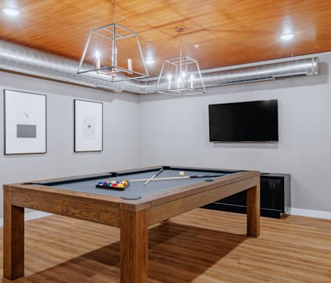 a game room with a pool table and a flat screen tv