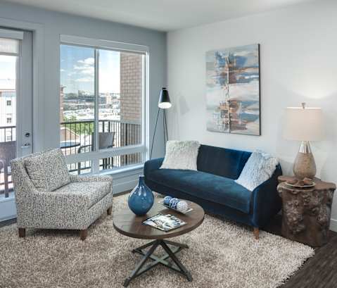 a living room with a blue couch and two chairs