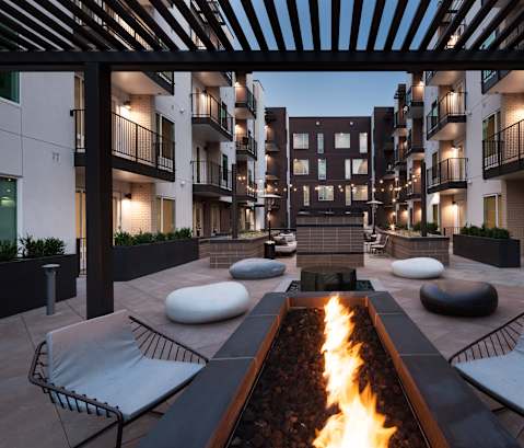 a courtyard with a fire pit and lounge chairs