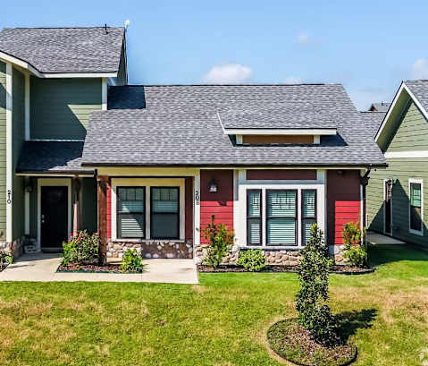a house with green and red siding and a gray roof