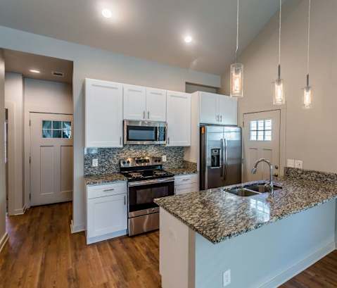 a kitchen with white cabinets and a granite counter top