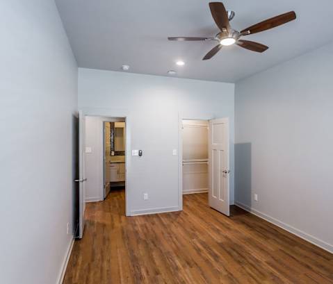 a bedroom with a ceiling fan and hardwood floors