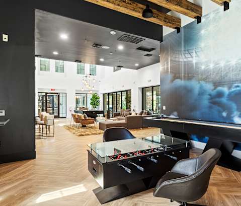 A billiard table is in the middle of a room with a pool table mural on the wall.