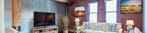 a living room with a brick wall and a television