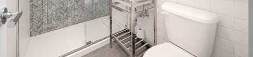 A white toilet sits next to a sink in a modern bathroom.