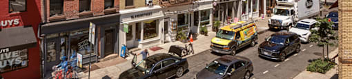A street view of a one way street with cars and buildings.