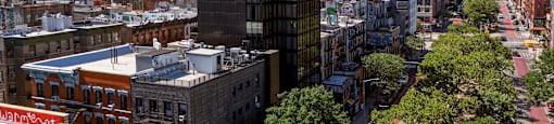 A city street with a bus and buildings on either side.