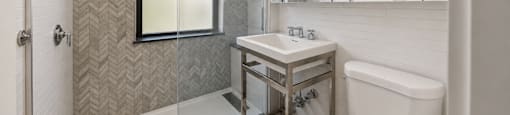 A bathroom with a white tub, sink, and toilet.