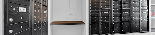 A room with a wall of black mailboxes and a row of mailboxes on the wall.