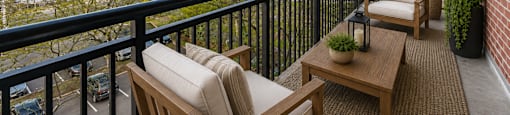 A balcony with a table and chairs overlooking a body of water.