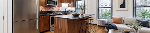 A modern kitchen with wooden cabinets and a stainless steel refrigerator.