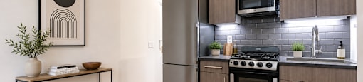 A modern kitchen with a stove top oven and a refrigerator.