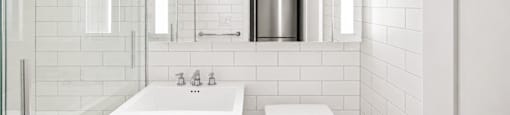 A white bathroom with a toilet, sink, and shower.