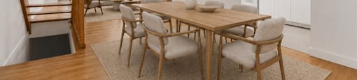 A dining room with a wooden table and chairs.