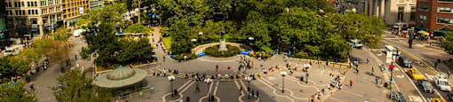 A busy city square with a lot of people walking around.
