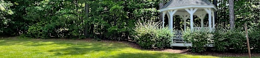 a white gazebo in the middle of a grassy area
