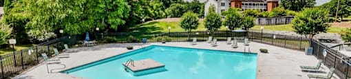 a swimming pool with lounge chairs and a hot tub