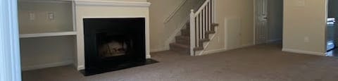 a living room with a ceiling fan and a fireplace