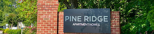 a brick wall with a sign that reads pine ridge apartments
