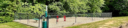 two children playing tennis on a court in a park