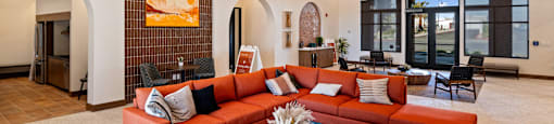 A living room with a red couch and a white coffee table.