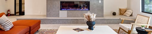 A living room with a fireplace and a painting above it.
