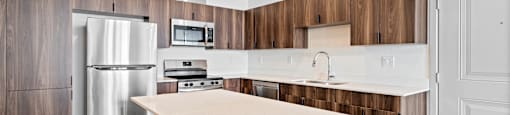 A modern kitchen with a white countertop and wooden cabinets.