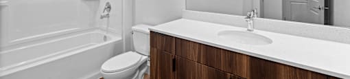 A white bathroom with a toilet, sink, and mirror.
