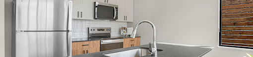 A modern kitchen with a large island and stainless steel appliances.