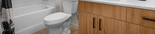 A white toilet sits next to a white sink in a bathroom.