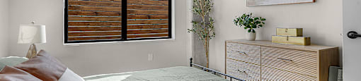 A bedroom with a large bed and a painting on the wall.
