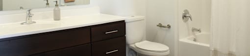 a bathroom with white walls and a white toilet next to a white sink and tub