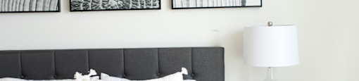 a bedroom with a bed and a nightstand with a lamp on it