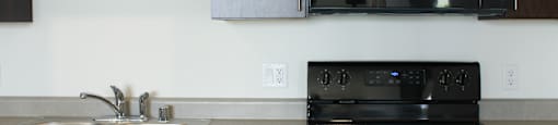 a kitchen with a black stove and a sink
