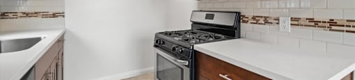 A kitchen with a black stove top oven and a microwave above it.