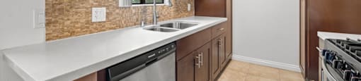A kitchen with brown cabinets and a white counter.