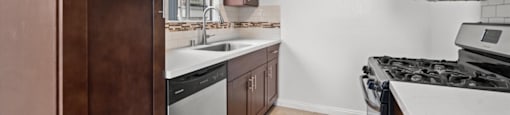 A kitchen with brown cabinets and a black stove top.