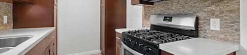 A kitchen with brown cabinets and a stove top oven.