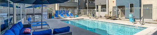 a pool with lounge chairs and umbrellas at Loma Villas Apartments, San Bernardino, 92408