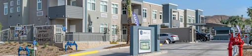 a row of apartment buildings with a parking lot in the foreground at Loma Villas Apartments, San Bernardino, 92408