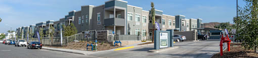 a row of apartment buildings with cars parked in front of them at Loma Villas Apartments, San Bernardino, 92408