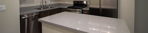 a kitchen with a large island and stainless steel appliances at Loma Villas Apartments in San Bernardino, CA