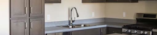 kitchen with a sink a stove and a microwave at Loma Villas Apartments, California
