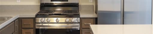 a kitchen with a stove refrigerator and microwave at Loma Villas Apartments, San Bernardino California