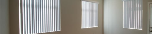 an empty room with three windows and a radiator at Loma Villas Apartments, San Bernardino, CA