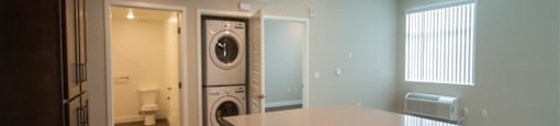 a kitchen with an island and a washer and dryer at Loma Villas Apartments, San Bernardino, CA