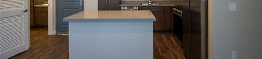 a kitchen with a center island next to a stove top oven at Loma Villas Apartments, San Bernardino California