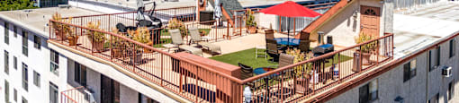 Rooftop deck with seating areas and red umbrella at Joro Properties Apartments, Hollywood, CA