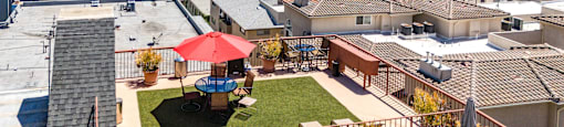 Rooftop patio with red umbrella and city views at Joro Properties Apartments, Hollywood, California