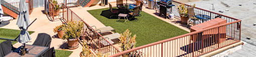 Rooftop patio with dining area and red umbrella at Joro Properties Apartments, Hollywood